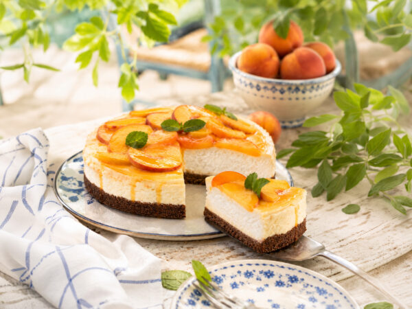 Cheesecake ψυγείου με βάση από ντακάκια ολικής άλεσης με χαρούπι, κρέμα γιαουρτιού και φρέσκα ροδάκινα.